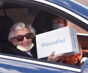 woman in car holding GrandPad box